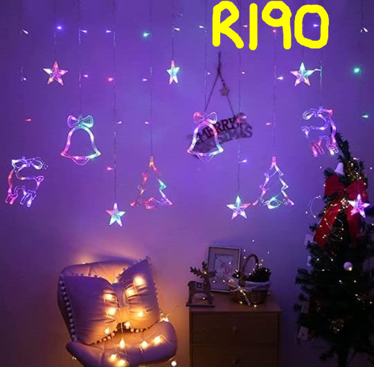 Decorative string lights shaped like stars, bells, and reindeer hanging against a purple wall with a Christmas tree and chair.