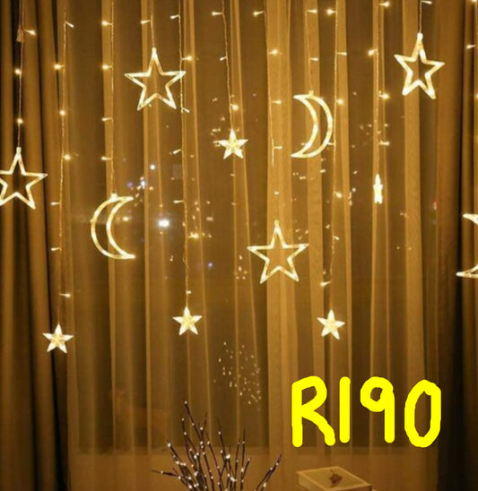 Decorative string lights shaped like stars and moons on a curtain