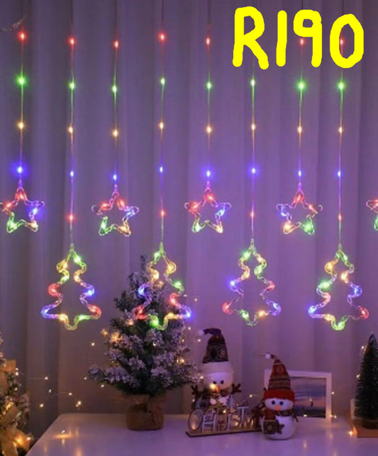 Colorful star-shaped LED lights hanging against a curtain with decorative items on a table below.